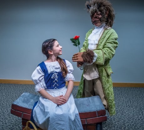 Beautiful Belle (Leah Fox) receives an enchanted rose from her Beast (Ethan Miller). Photo by Val Proudkii. 